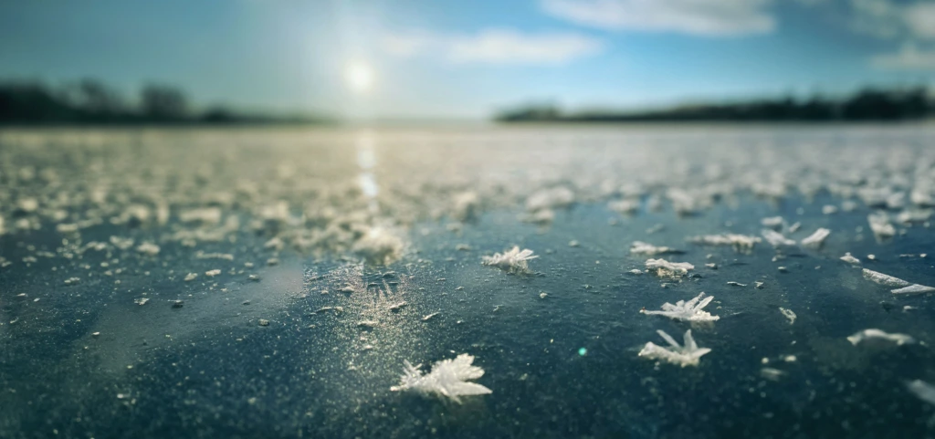 Foto av is på vatten, med iskristaller på.