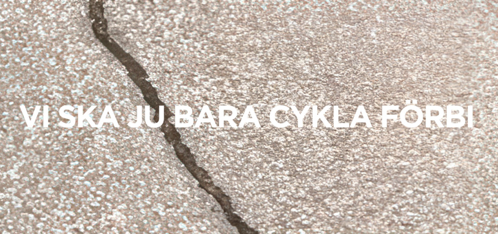 En närbild av en asfaltsyta med en spricka som går diagonalt genom bilden. Texten "Vi ska ju bara cykla förbi" står i stora vita bokstäver till höger. Lähikuva asfaltista, jossa on halkeama vinosti kuvan poikki. Valkoinen teksti "Mehän vain pyöräillään ohi" näkyy oikealla. A close-up of an asphalt surface with a crack running diagonally across the image. The white text “We’re just going to cycle past” appears on the right side.