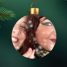 Ett runt julgransornament i glas med en närbild av två leende personer bredvid varandra, fångade i en varm och lekfull stämning mot en mörkgrön bakgrund.
Pyöreä lasinen joulukuusikoriste, jossa on lähikuva kahdesta hymyilevästä henkilöstä vierekkäin, lämpimässä ja leikkisässä tunnelmassa tummanvihreää taustaa vasten.
A round glass Christmas ornament featuring a close-up of two smiling people side by side, captured in a warm and playful moment against a dark green background.