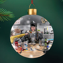 Ett runt julgransornament i glas med en humoristisk scen där en person i full riddarrustning sitter i ett stökigt kök medan ett barn räcker fram en gaffel.
Pyöreä lasinen joulukuusikoriste, jossa nähdään humoristinen kohtaus: haarniskaan pukeutunut henkilö istuu sotkuisessa keittiössä, kun lapsi ojentaa hänelle haarukan.
A round glass Christmas ornament featuring a humorous scene of a person in full knight’s armor sitting in a messy kitchen as a child hands them a fork.
