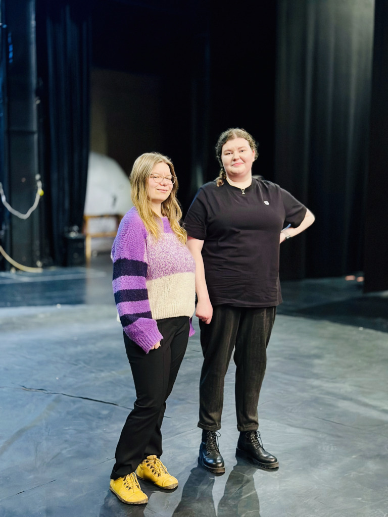 Noora och Susanna stor på stora scenen på ÅST. I vanliga kläder. De är teaterinfluencers.